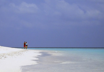 Image showing man and woman walking trough white sand tropical beach