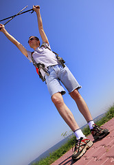 Image showing Hiker with raised arms and trekking sticks