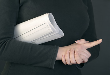 Image showing Woman hands and rolled newspaper