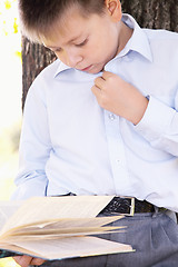 Image showing Serious boy reading book