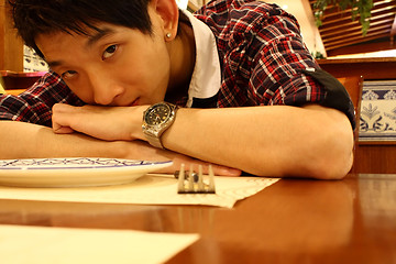 Image showing Portrait of a asia man bend on the table