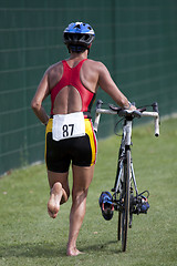 Image showing Triathlete pushing his bike 