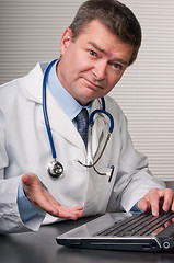 Image showing Friendly doctor looks at camera and gestures