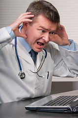 Image showing Doctor gestures in despair at information on laptop