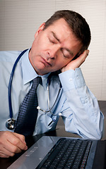 Image showing Tired doctor sleeps at desk