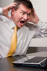 Image showing Shocked business man raises hands to head