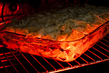 Image showing lasagne in the owen still cooking . 