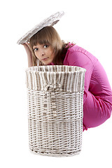 Image showing Girl peers out for baskets for linen