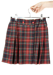 Image showing Feminine hand keeps plaid skirt