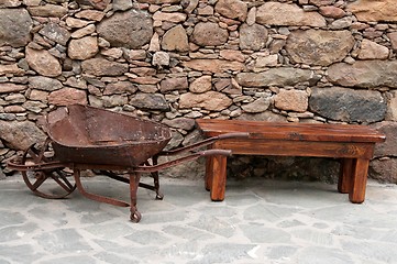 Image showing Old wheelbarrow and bench