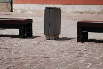 Image showing Two stone benches and trash