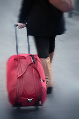 Image showing women walking, pulling suitcase, blurred motion