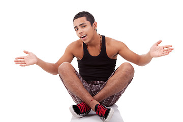 Image showing young man with open arms, sitting on floor