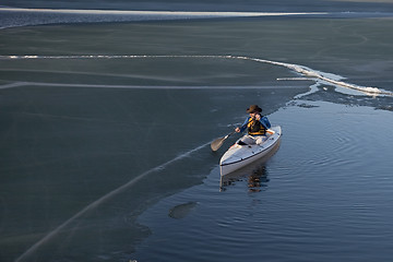 Image showing canoe paddling on ice covered lake