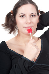 Image showing Portrait of pretty woman in black eating candy