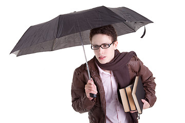 Image showing Young boy with an umbrella carrying books