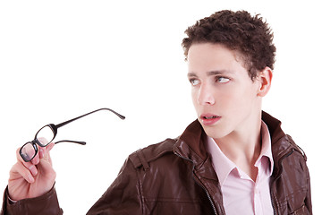 Image showing Young boy looking serious, with glasses in hand