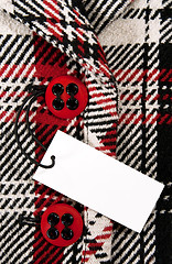 Image showing Blank price tag on checked coat with red buttons
