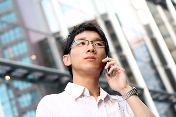 Image showing casual asian businessman talking on his cell phone 