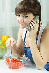 Image showing Housewife with phone eating fresh  salad