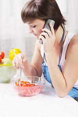 Image showing Housewife talking on phone eating fresh salad