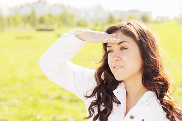 Image showing Young woman looking from under hand peak