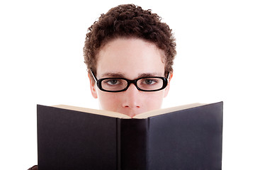 Image showing Young man with glasses, peering over an open book