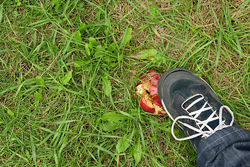 Image showing Man's foot crushing a red apple