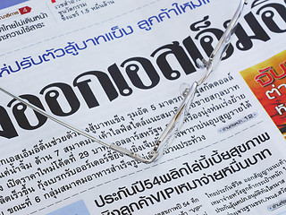 Image showing Close-up of Thai language newspaper and a pair of glasses.