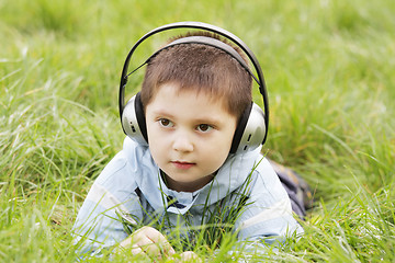 Image showing Serious boy laying in grass