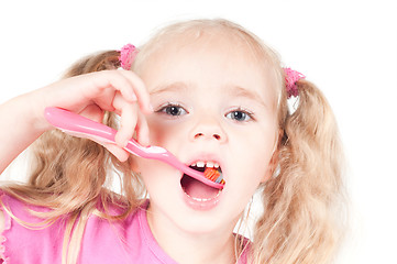 Image showing Little cute girl in studio brushing teeth