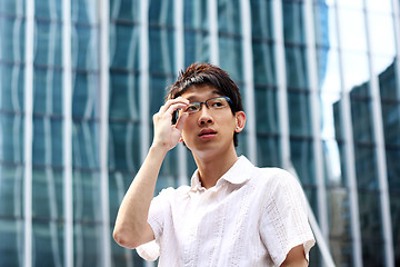 Image showing asian businessman holding glasses