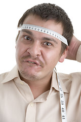 Image showing man measuring his head