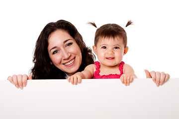 Image showing Mother and baby daughter holding white board