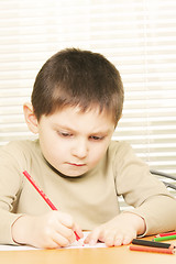 Image showing Concentrated boy drawing with crayon