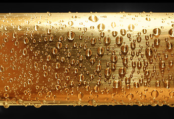 Image showing water drops on golden metal