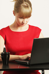 Image showing Blonde businesswoman in red typing on laptop