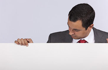 Image showing Businessman holding a blank billboard