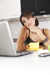 Image showing Modern woman reading e-mails at her breakfast