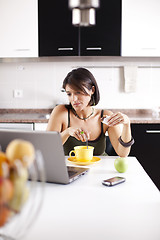 Image showing Modern woman reading e-mails at her breakfast