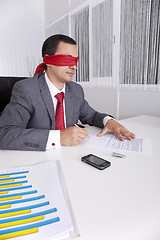 Image showing Blindfold businessman working with his laptop