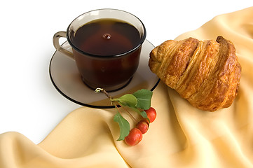 Image showing Brown cup of tea and croissants