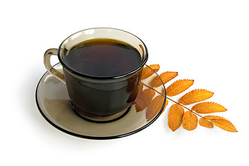 Image showing Coffee-brown cup with a mountain ash leaf