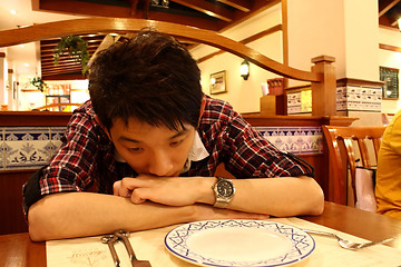 Image showing Portrait of a asia man bend on the table