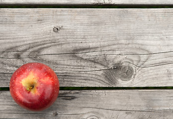 Image showing Red apple on old wooden table from above