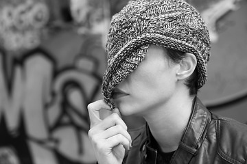 Image showing Woman hiding behind her cap