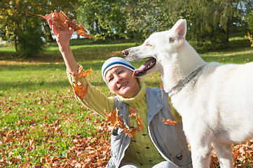 Image showing The woman with a white dog in autumn park