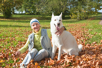 Image showing The woman with a white dog in autumn park