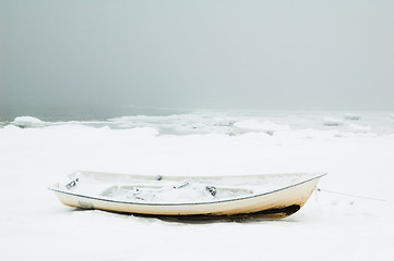 Image showing Fishing boat on the bank of the frozen sea