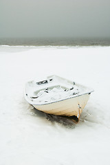 Image showing Fishing boat on the bank of the frozen sea